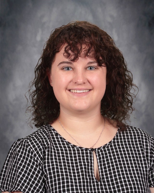 Picture of Claire Johnson on a grey background and a white and black shirt