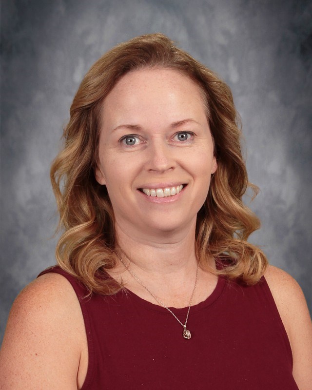 Picture of Mrs. Moore on a grey background and red shirt on