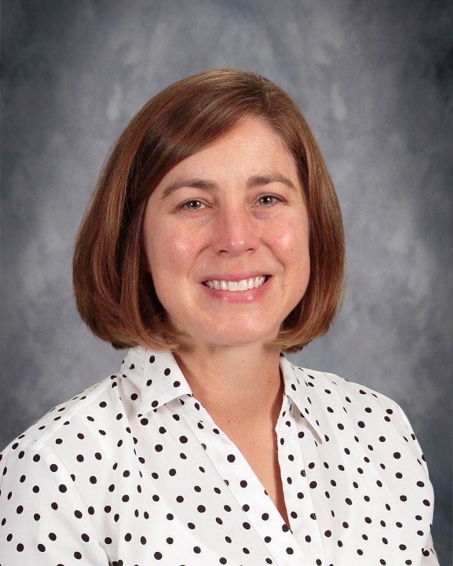 Picture of Leslie Wilson on a grey background and a white shirt with black polka dots on it