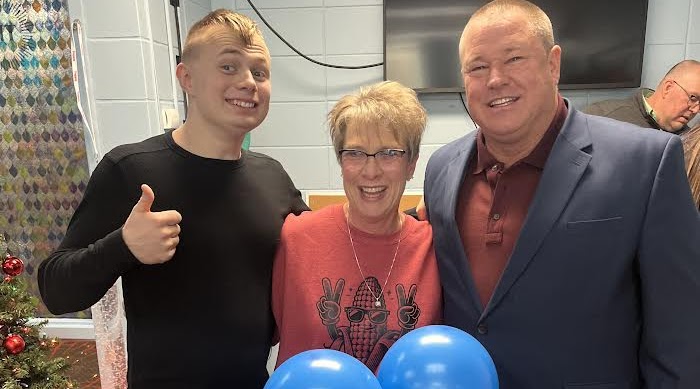 Three people take a photo to celebrate the employee of the month